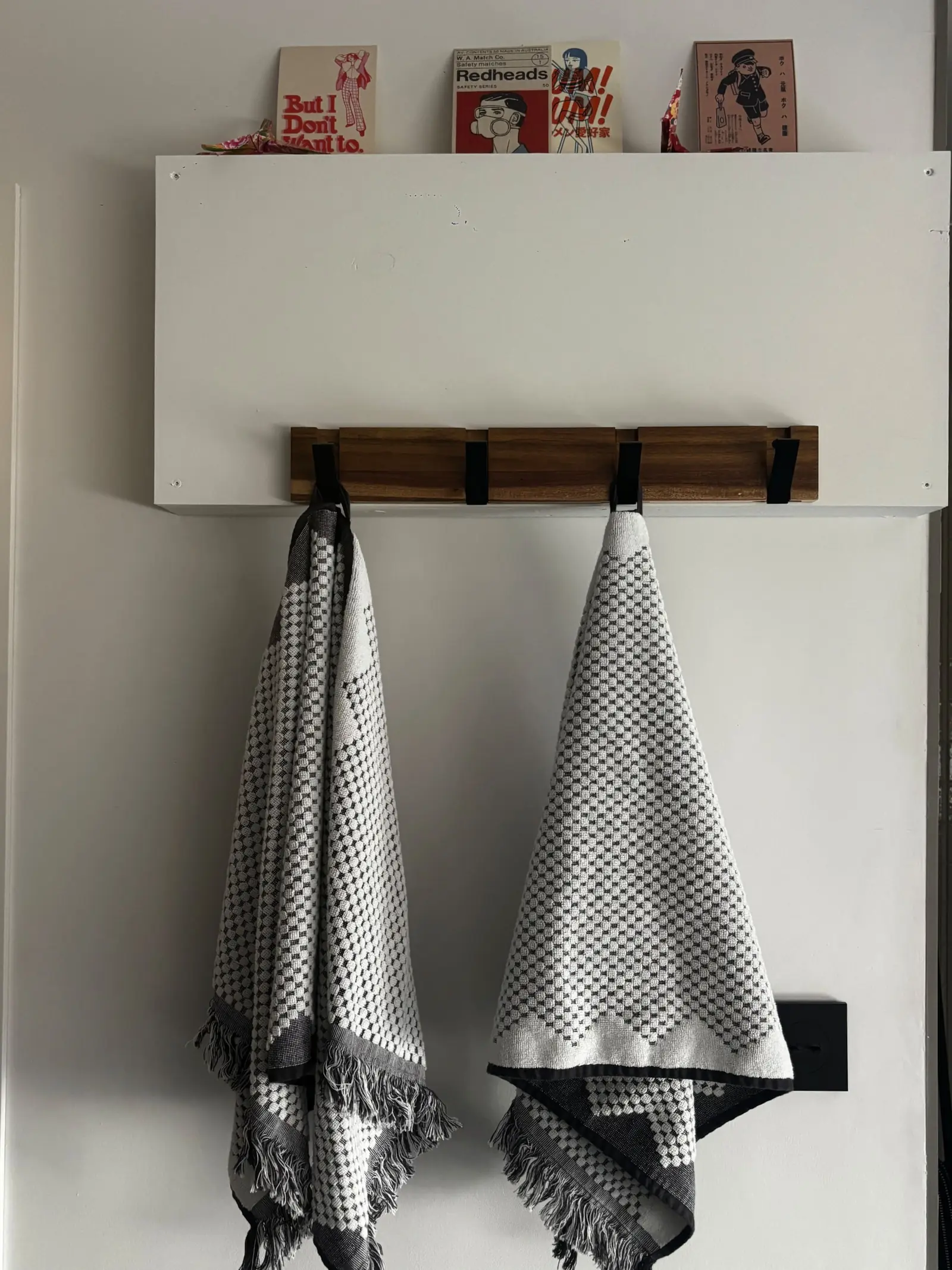 Serviettes à motifs noirs et blancs suspendues à la patère en bois