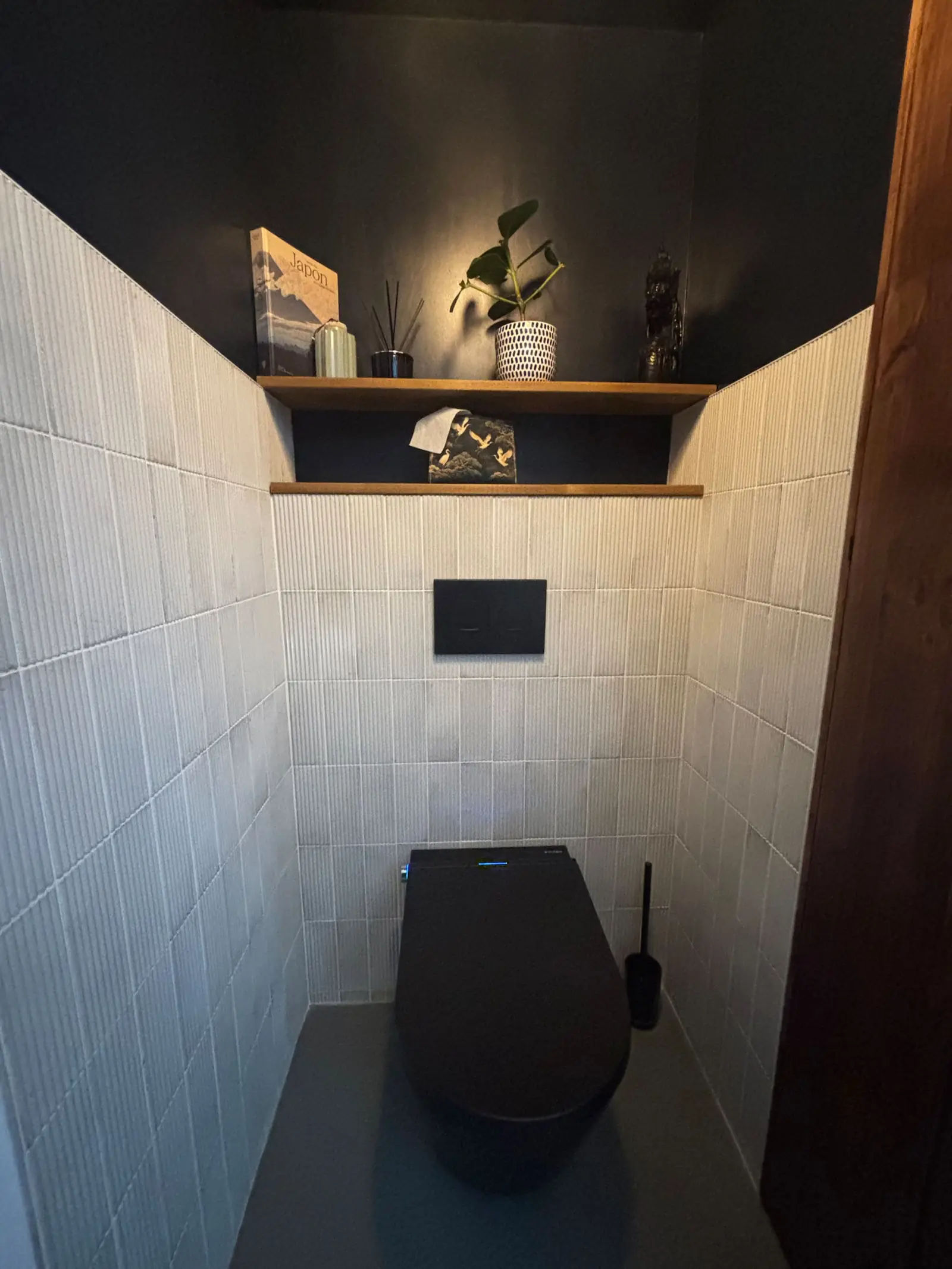 Les toilettes japonaises dans l’alcôve carrelée de blanc